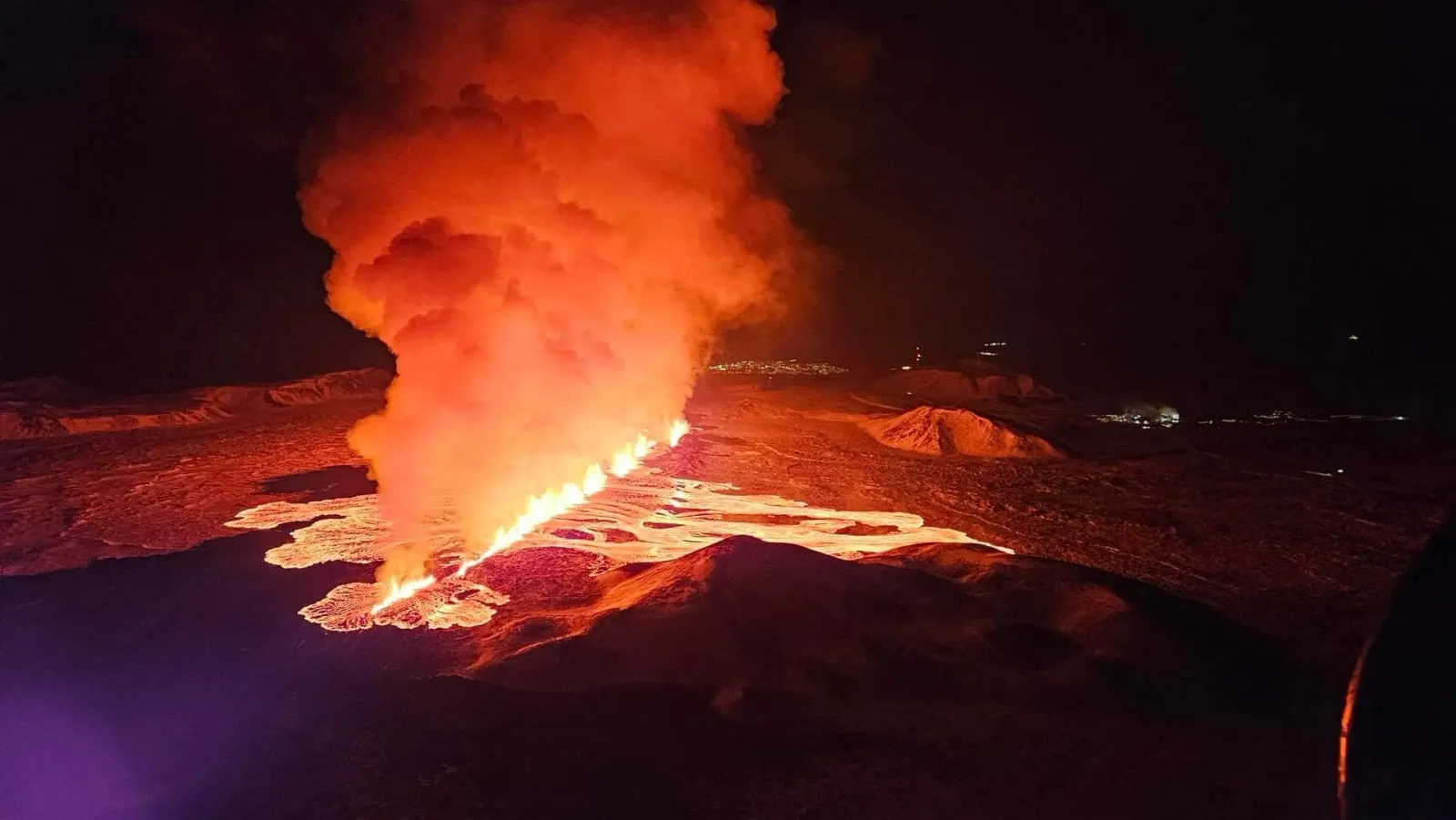 Éruption fissurale de lave la nuit sur la péninsule de Reykjanes, avec des coulées orange incandescentes sur un champ de basalte sombre, Islande